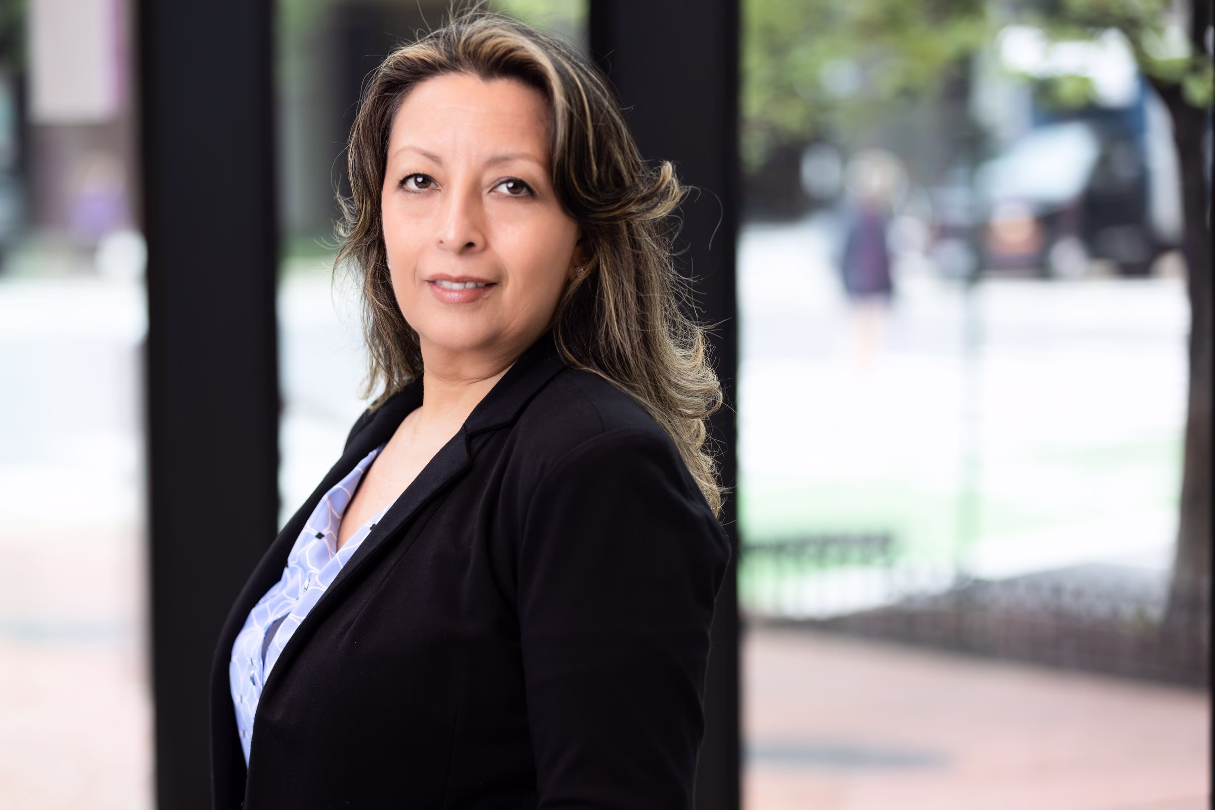 A professional female team member at Georgetown Cosmetic Dentistry in Washington DC wearing a black blazer outdoors